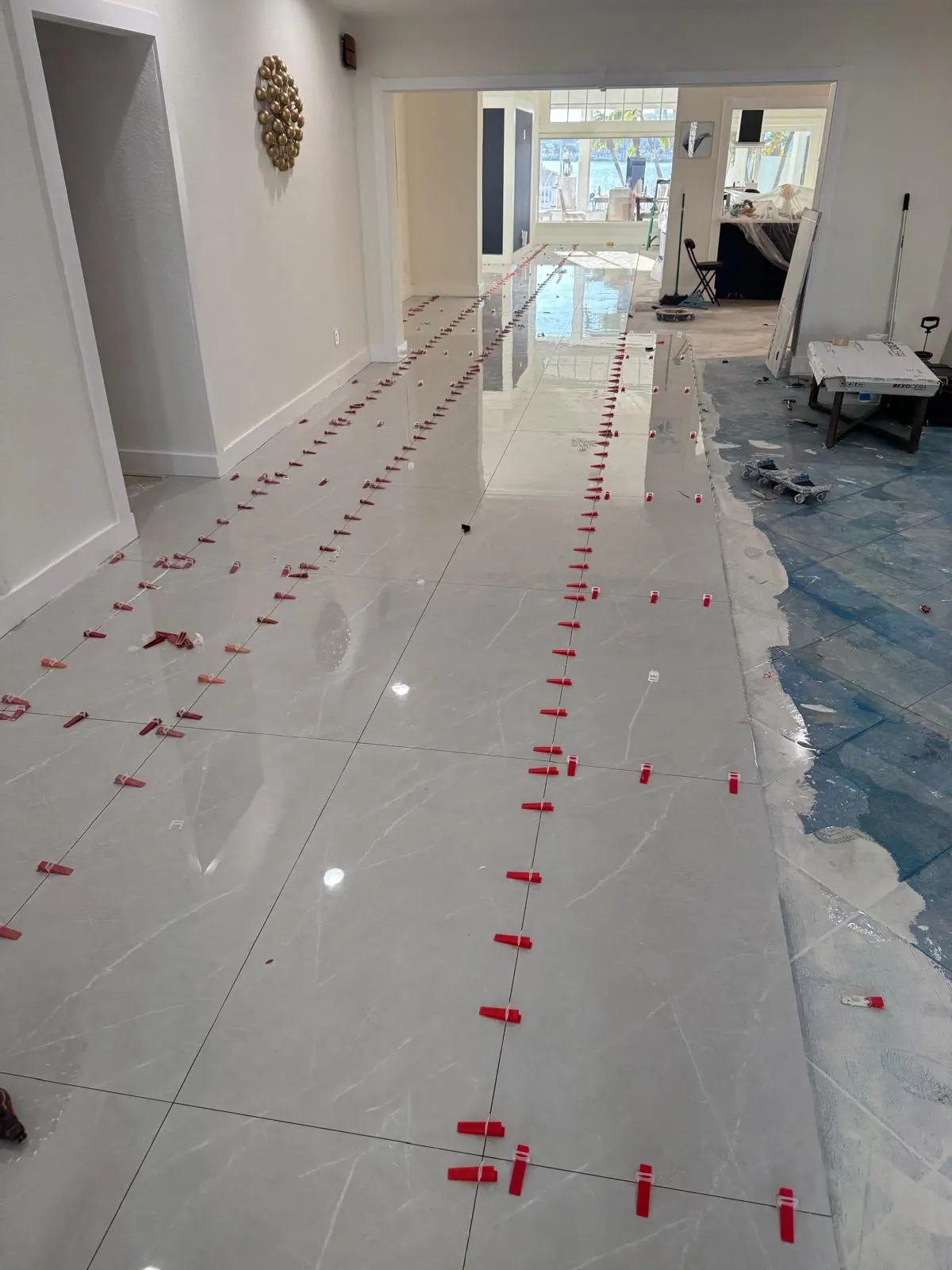 A view of a floor tile installation in progress with spacers in place.