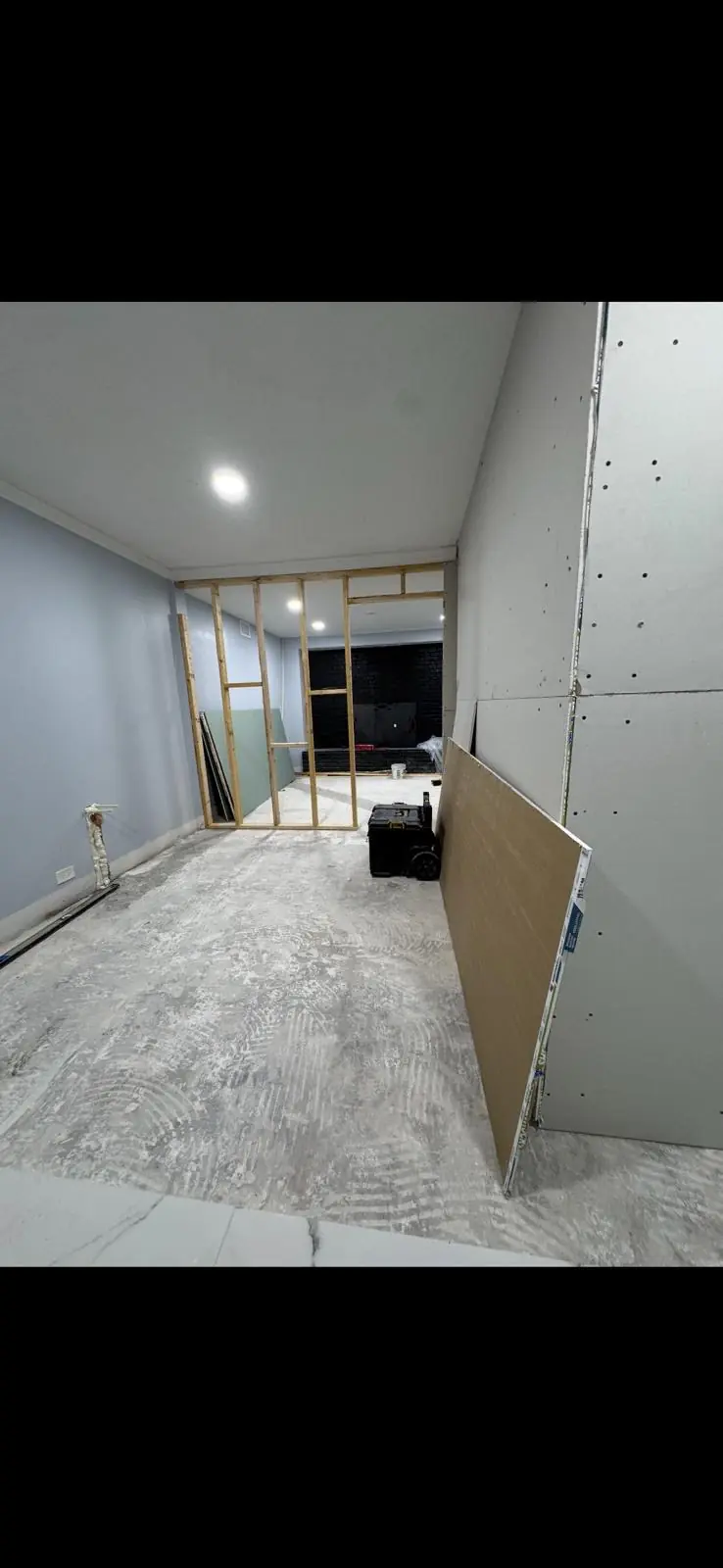 A view of a room under construction with materials and tools visible.